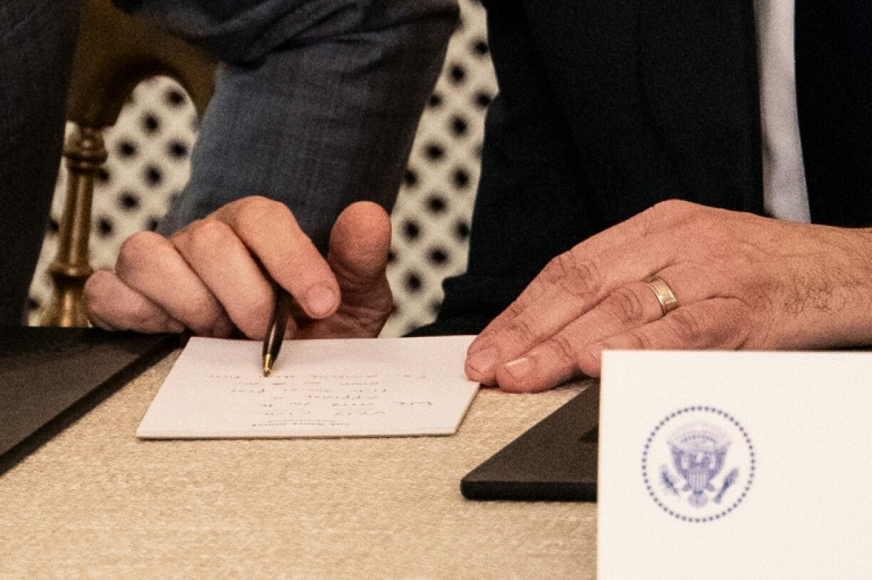 White House Deputy Chief of Staff Stephen Miller reads the handwritten note handed to US President Donald Trump by his top diplomat Marco Rubio signalling a Gaza deal was near