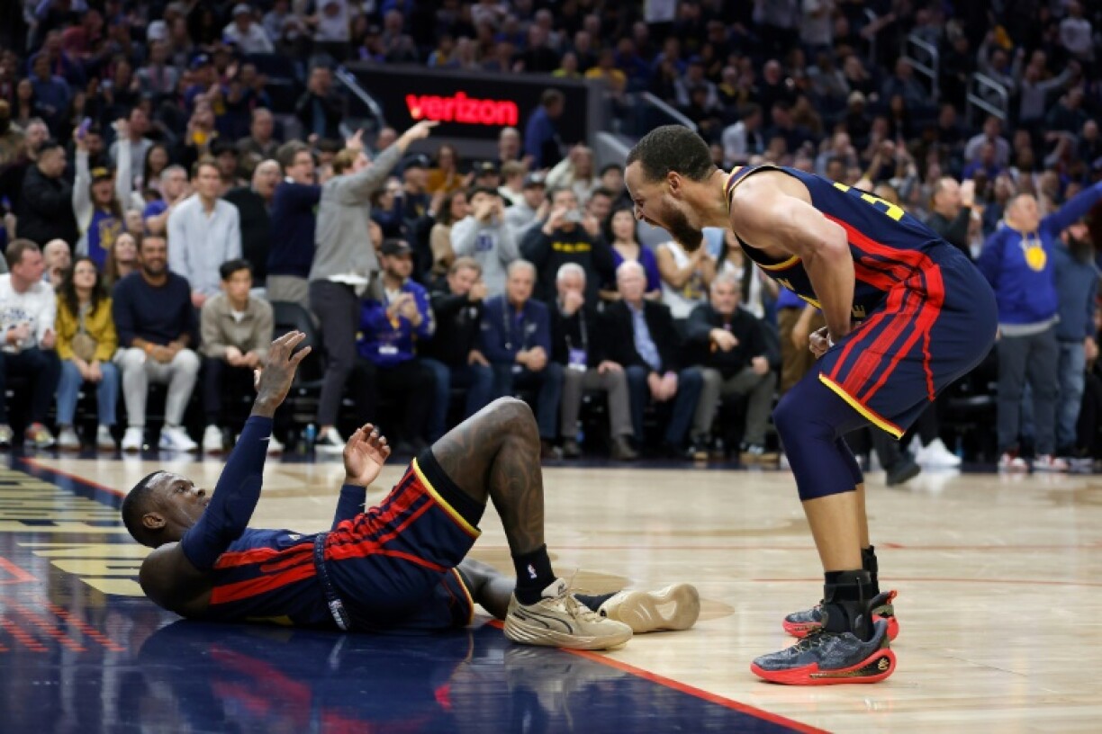 Stephen Curry of the Golden State Warriors reacts with teammate Dennis Schroder after a play in the Warriors' NBA victory over the Oklahoma City Thunder
