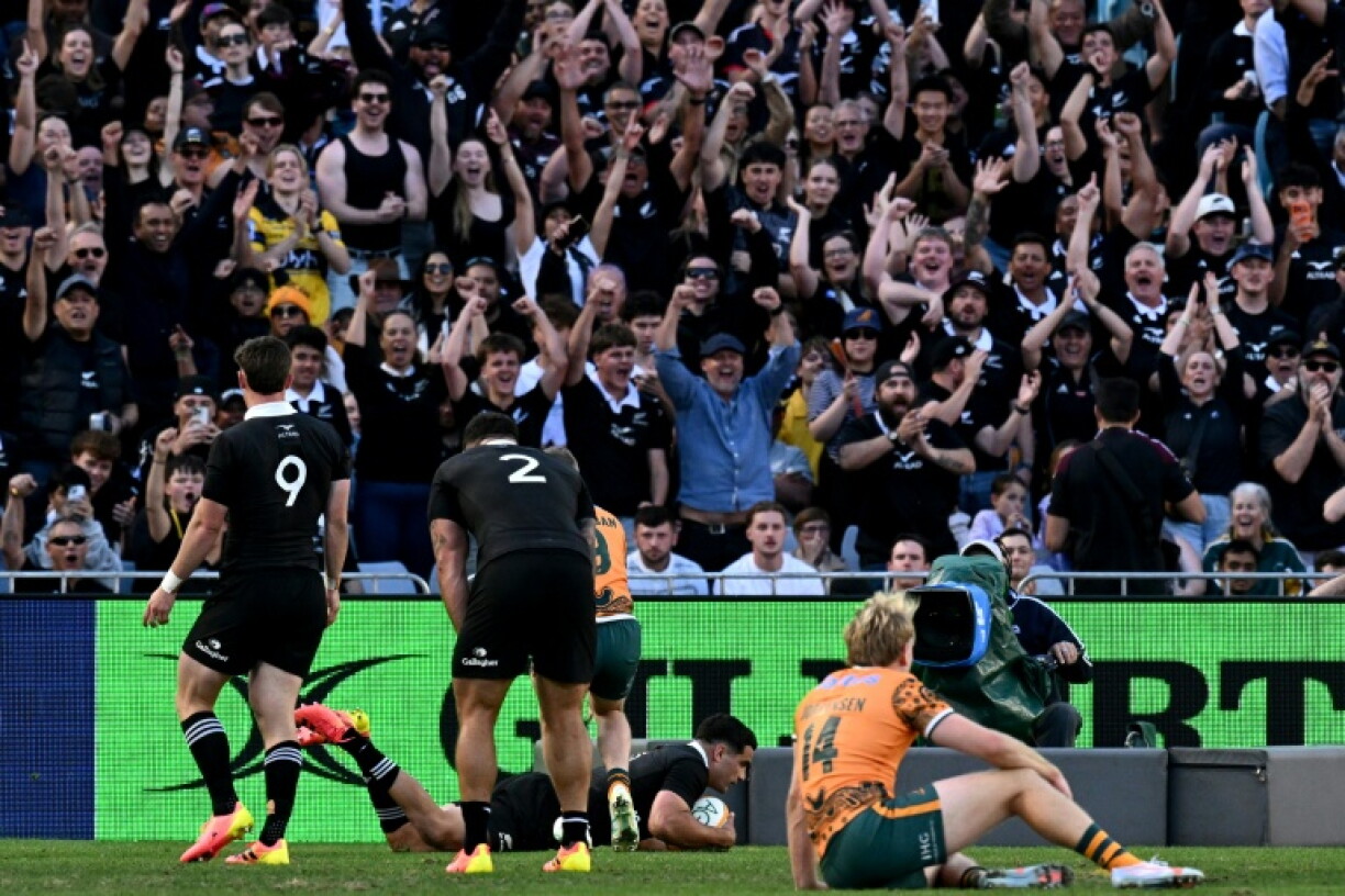 New Zealand's Josh Moorby (C) scores a try against Australia