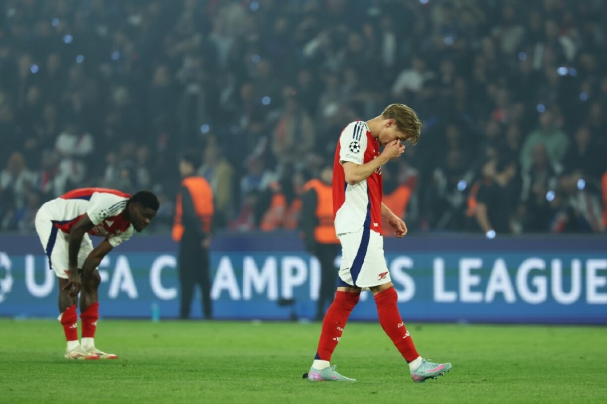 Arsenal's players react after their Champions League defeat against Paris Saint-Germain