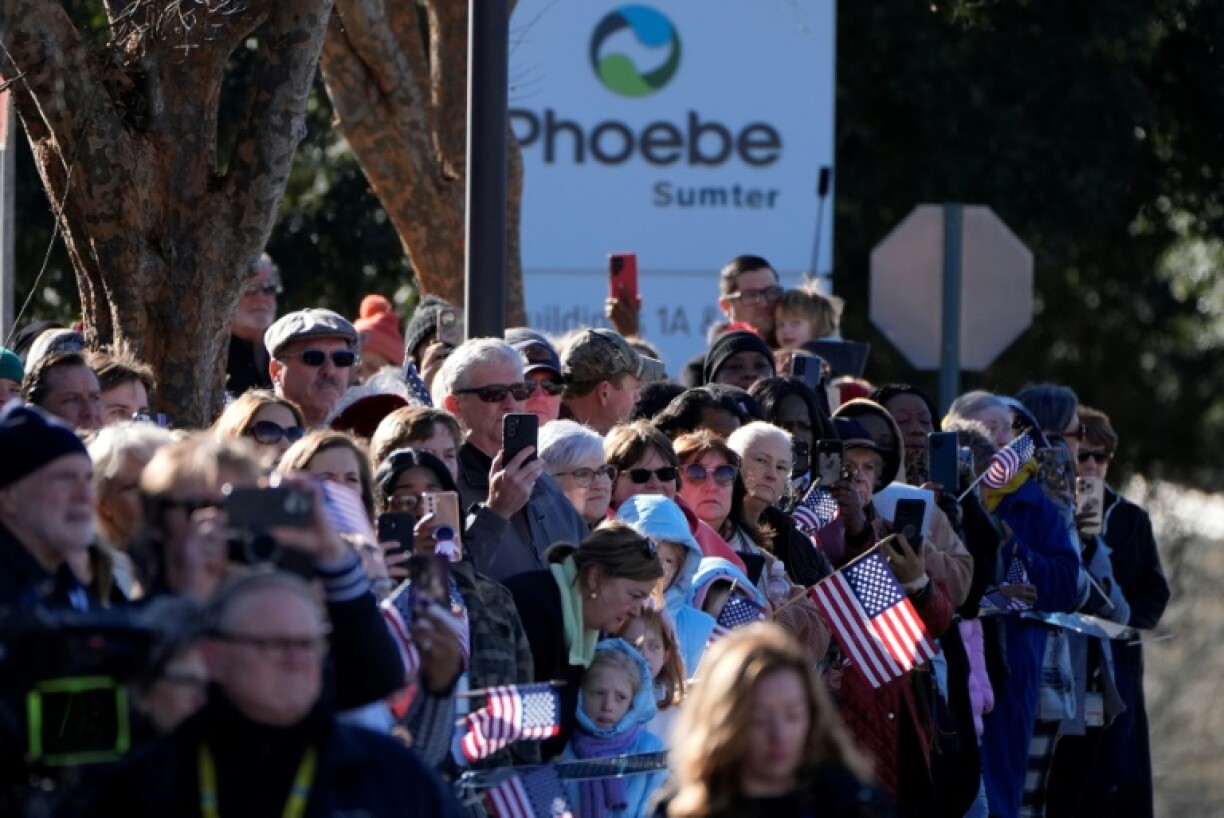 Mourners gather before the flag-draped casket of Jimmy Carter departs Americus, Georgia, on January 4, 2025 to drive through the former president's hometown of Plains