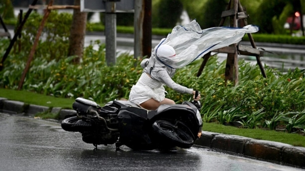 Une femme en moto est emportée par les rafales provoqués par le typhon Yagi dans la ville de Hai Phong, au Vietnam, le 7 septembre 2024