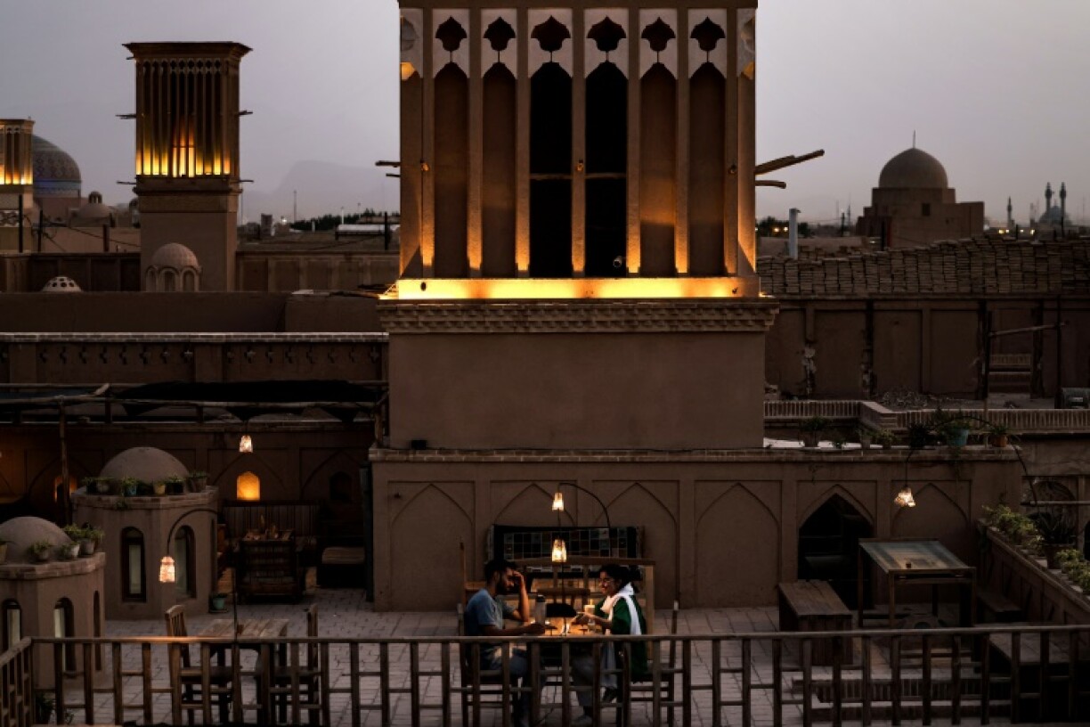 Photo d'un tour à vent près d'une terrasse d'un café sur un toit de la ville de Yazd, au centre de l'Iran, le 3 juillet 2023