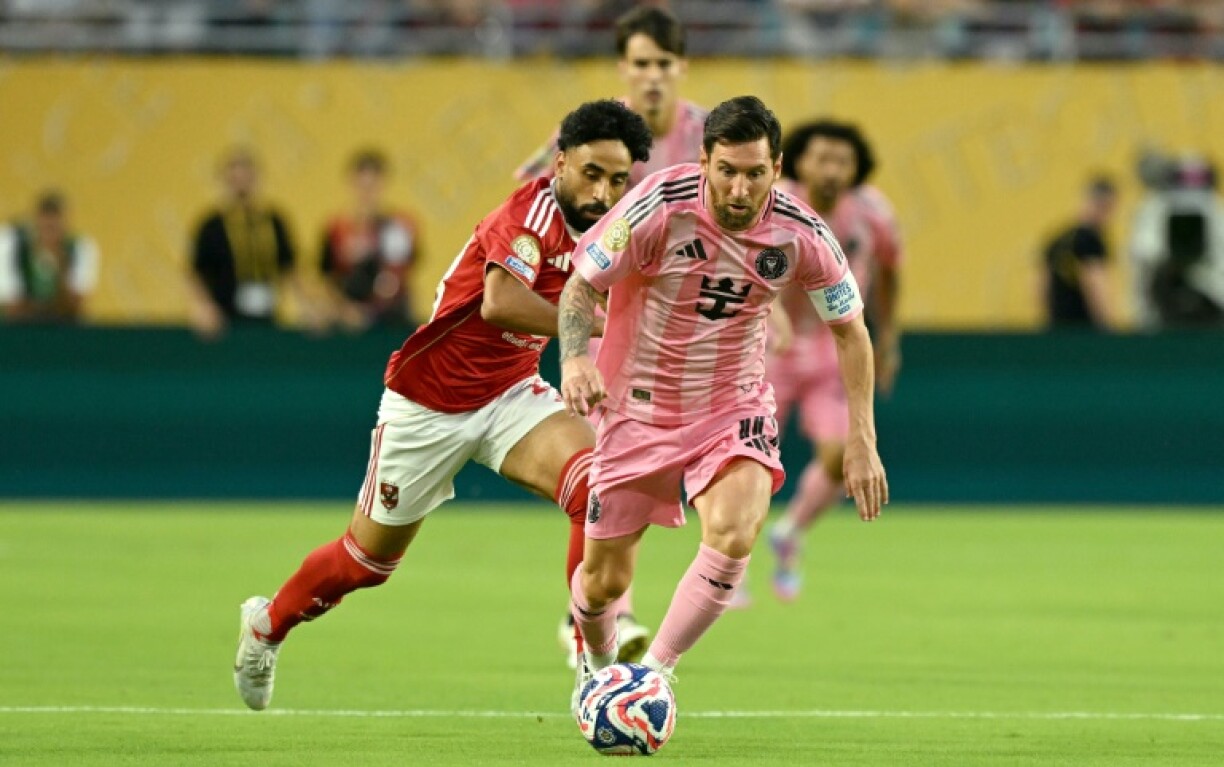 Al Ahly's Marwan Attia and Inter Miami's Lionel Messi fight for the ball during the opening game of the Club World Cup.