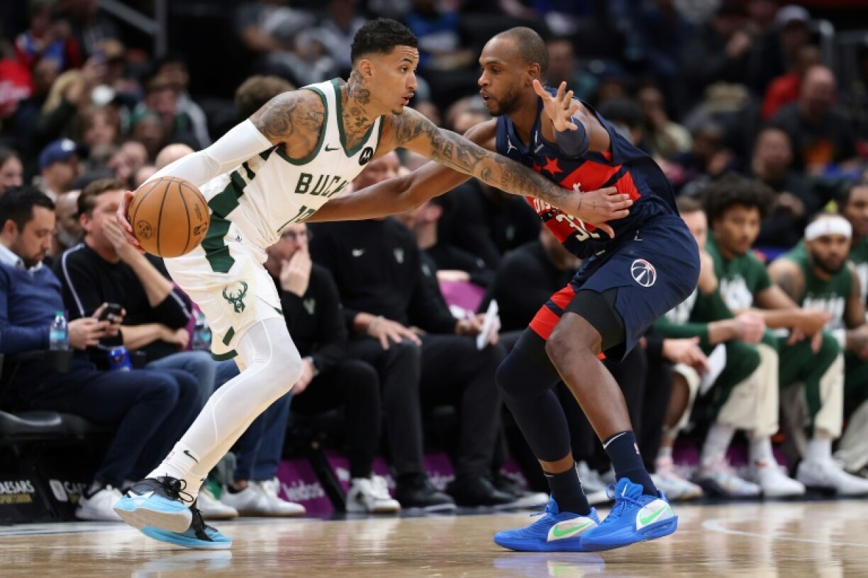 Kyle Kuzma of the Milwaukee Bucks is guarded by Khris Middleton of the Washington Wizards in the Bucks' NBA victory over the Wizards