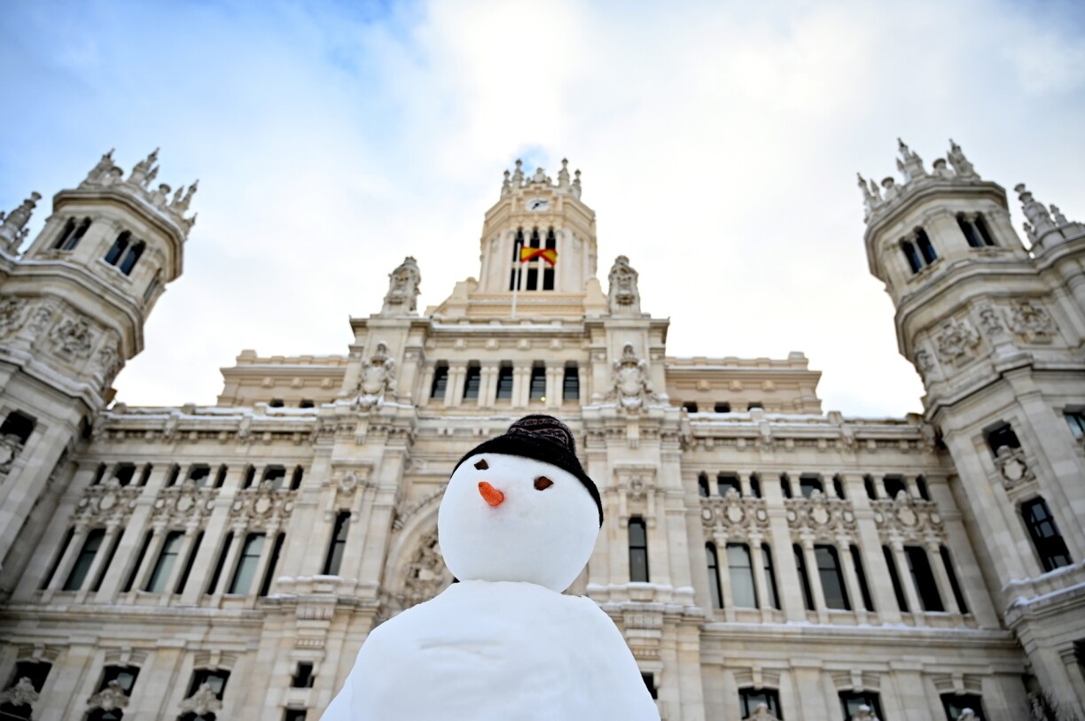 A snowman is built outside the Cibeles Palace in Madrid on January 10, 2021. Snowstorms in Spain left three people dead and caused chaos across much of the country, trapping motorists and shutting down the capital's air and rail links.