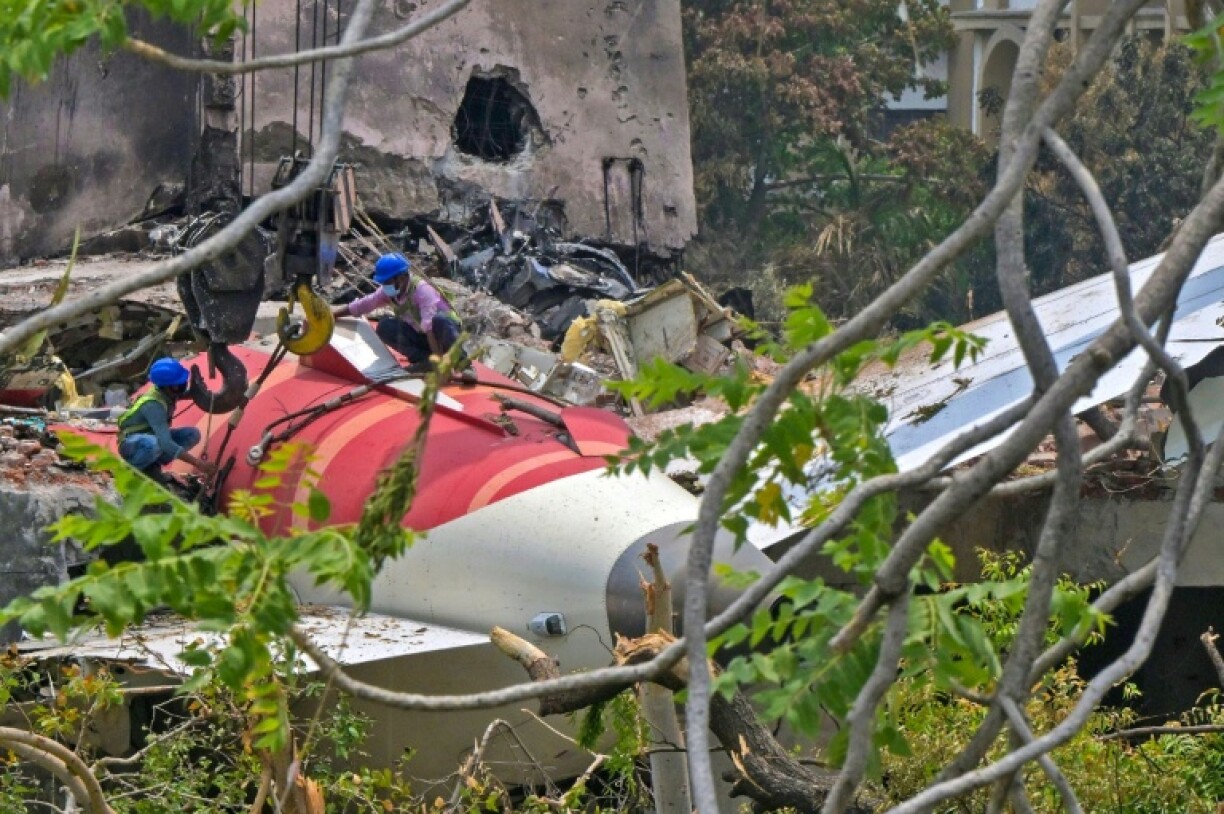 Emergency services removed a badly burnt body from the tailpiece of an Air India plane that crashed in Ahmedabad, killing at least 279 people, before the wreckage was removed