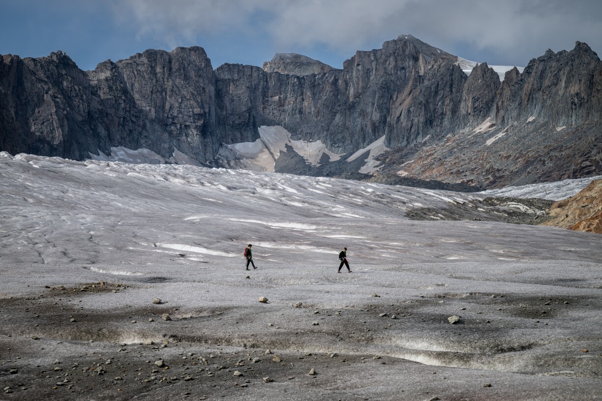 Cette photographie prise au-dessus de Gletsch, dans les Alpes suisses, montre deux alpinistes en randonnée sur le glacier du Rhône, le 12 septembre 2025.