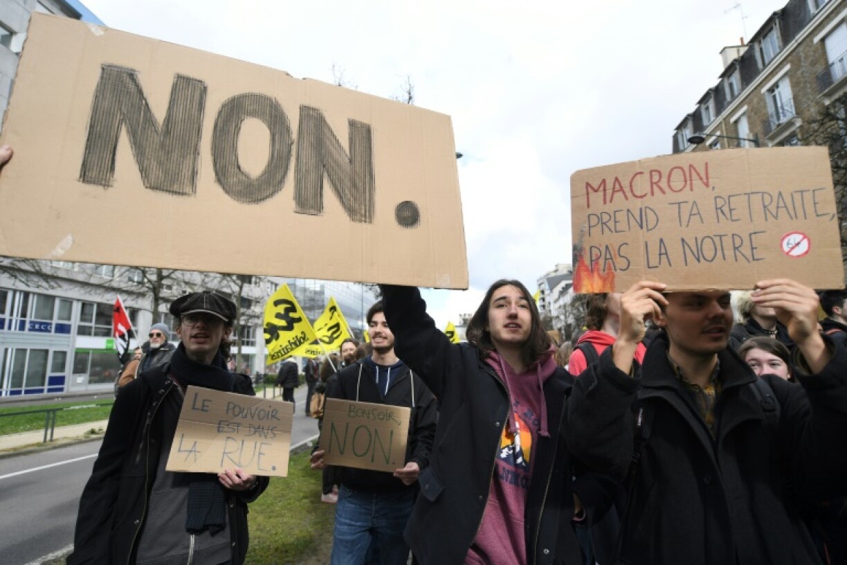 Des manifestants tiennent des pancartes exprimant leur opposition à la réforme des retraites à Rennes (Ille-et-Vilaine), le 17 mars 2023