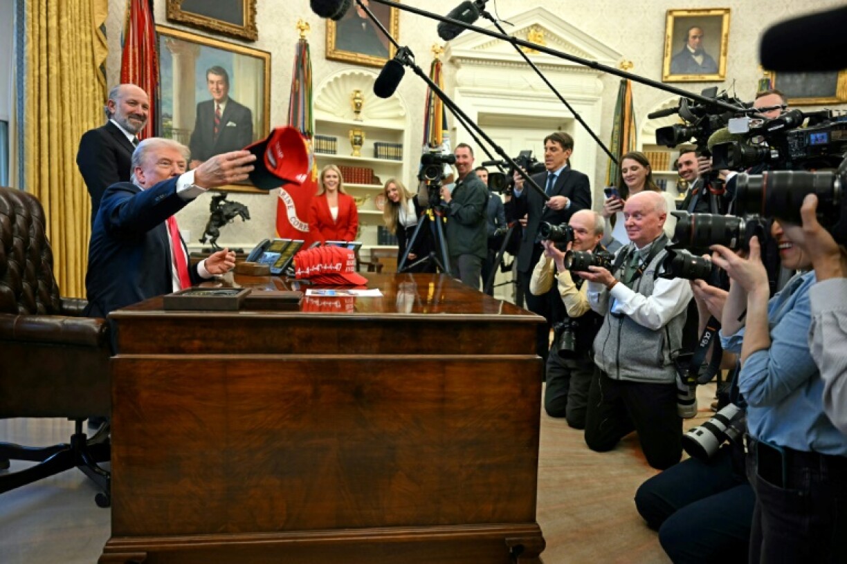 US President Donald Trump throws a hat reading