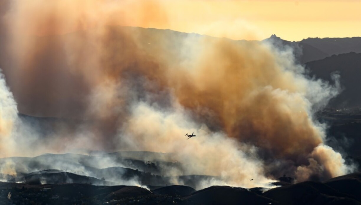 Small aircraft periodically guided giant tankers that dumped bright-red retardant onto the flames