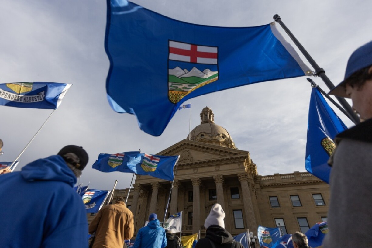 People fly flags at an Alberta Independence Rally in Canada ahead of a vote on whether it wants a referendum