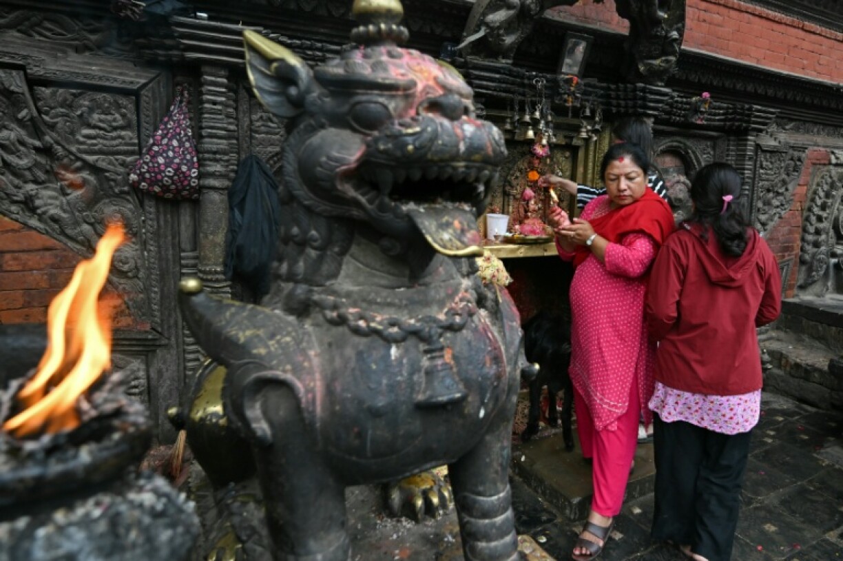 Women offer prayers in Bhaktapur on the outskirts of Kathmandu. Flags flew at half-mast during a national day of mourning on September 17 those killed in anti-corruption protests that toppled the government