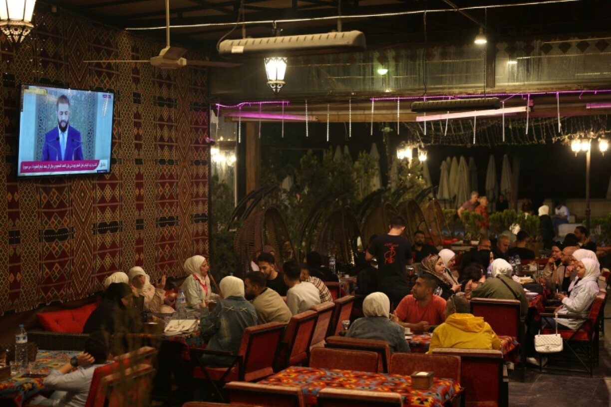 Syrians watch a televised speech by Syria's leader Ahmed al-Sharaa -- who until recently was on a US wanted list over jihadist connections -- at a cafe in Aleppo on May 14, 2025