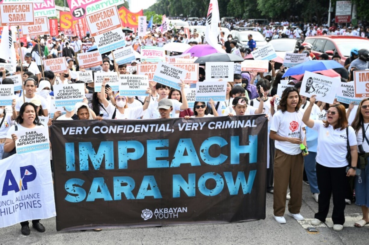 Protesters holding placards shout slogans during a rally at the People Power monument in Manila