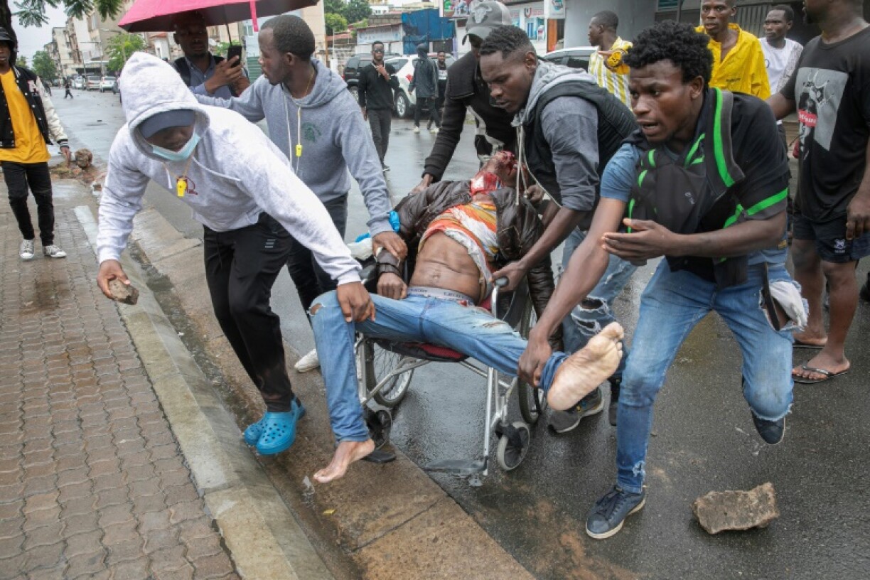 People rallied around a man shot during clashes with riot police in Maputo as large crowds turned out to welcome the opposition leader home