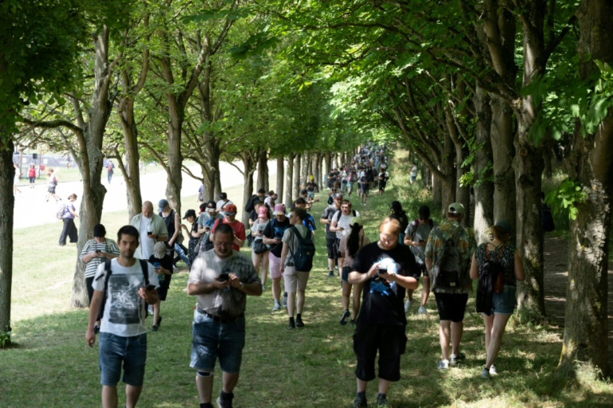 Des fans jouent à Pokémon Go sur leurs smartphones, le jour de l'ouverture du Pokémon Go Fest 2025, au Parc de Sceaux, au sud de Paris, le 13 juin 2025
