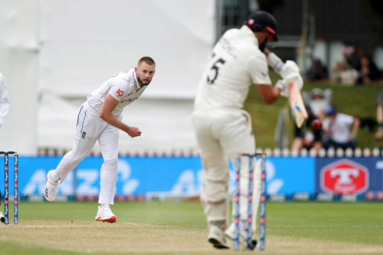 England's Gus Atkinson (L) bowls to New Zealand's Daryl Mitchell