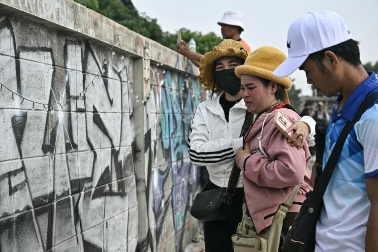 Friends and relatives wait for news about possible survivors at the site of an under-construction building collapse in Bangkok