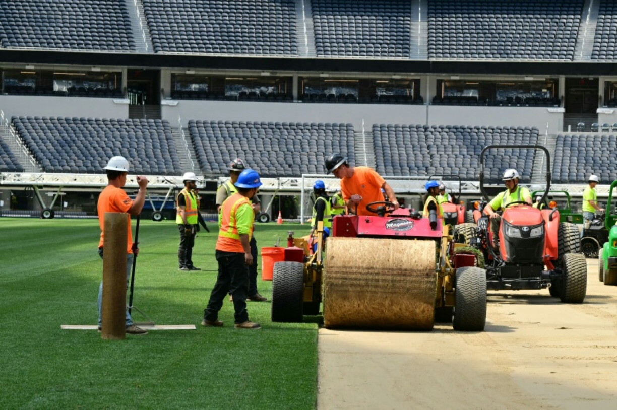 Des ouvriers posent la pelouse du SoFi Stadium à Inglewood, près de Los Angeles (Californie), le 13 mai 2026 avant le début du Mondial de football
