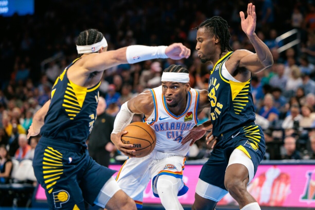 NBA Most Valuable Player Shai Gilgeous-Alexander of Oklahoma City drives to the basket around two defenders for the Indiana Pacers, who will play the Thunder in the NBA Finals