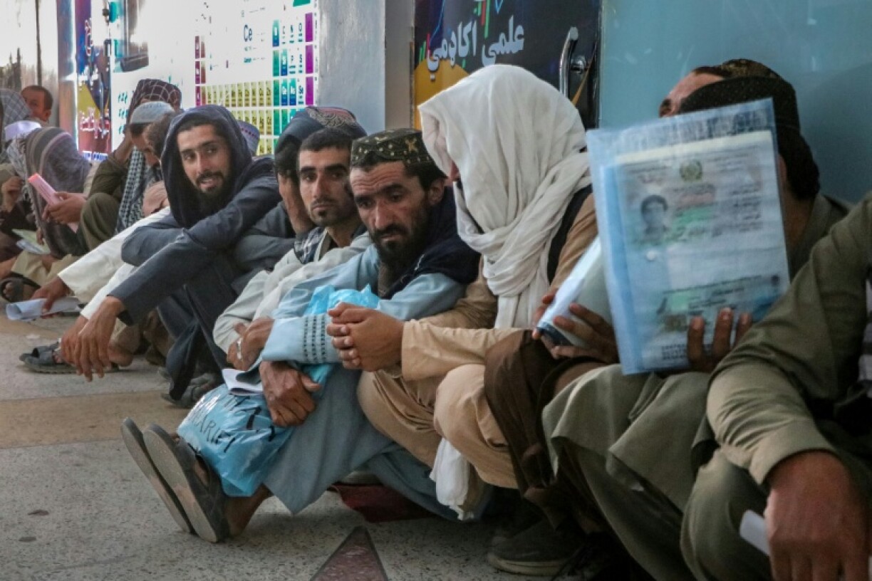 Afghan men wait in queues to submit their documents while applying for job vacancies in Qatar