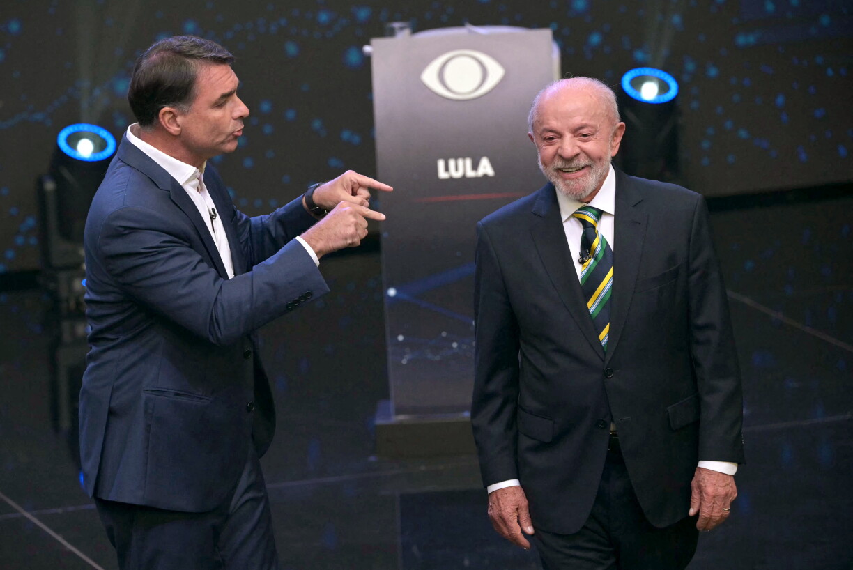 Le président brésilien et candidat à la présidence, Luiz Inácio Lula da Silva, sourit alors que le candidat de droite à la présidence, Flavio Bolsonaro, prend la parole lors d'un débat en amont du second tour de l'élection présidentielle, à São Paulo (Brésil), le 18 octobre 2026.