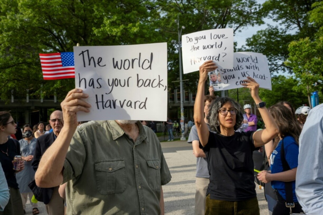 People hold signs in rally in support of international students at Harvard University