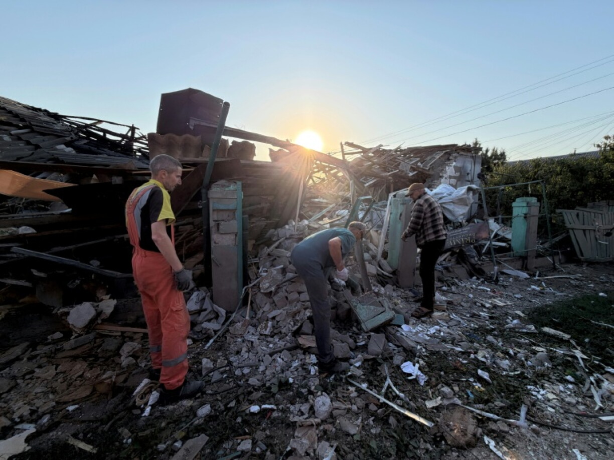 Des habitants déblaient les gravats d'une habitation détruites dans une attaque aérienne russe qui a fait deux morts à Zaporijjia, dans le sud de l'Ukraine, le 12 septembre 2026