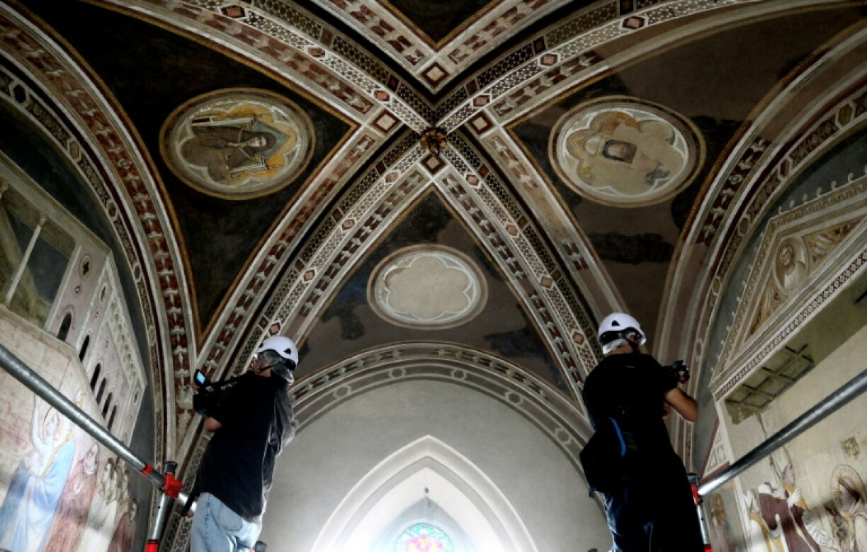 Des cameramen filment les fresques lors d'une visite de presse marquant la fin des travaux de restauration des fresques du XIVe siècle de Giotto dans la basilique Santa Croce à Florence, le 12 juin 2026