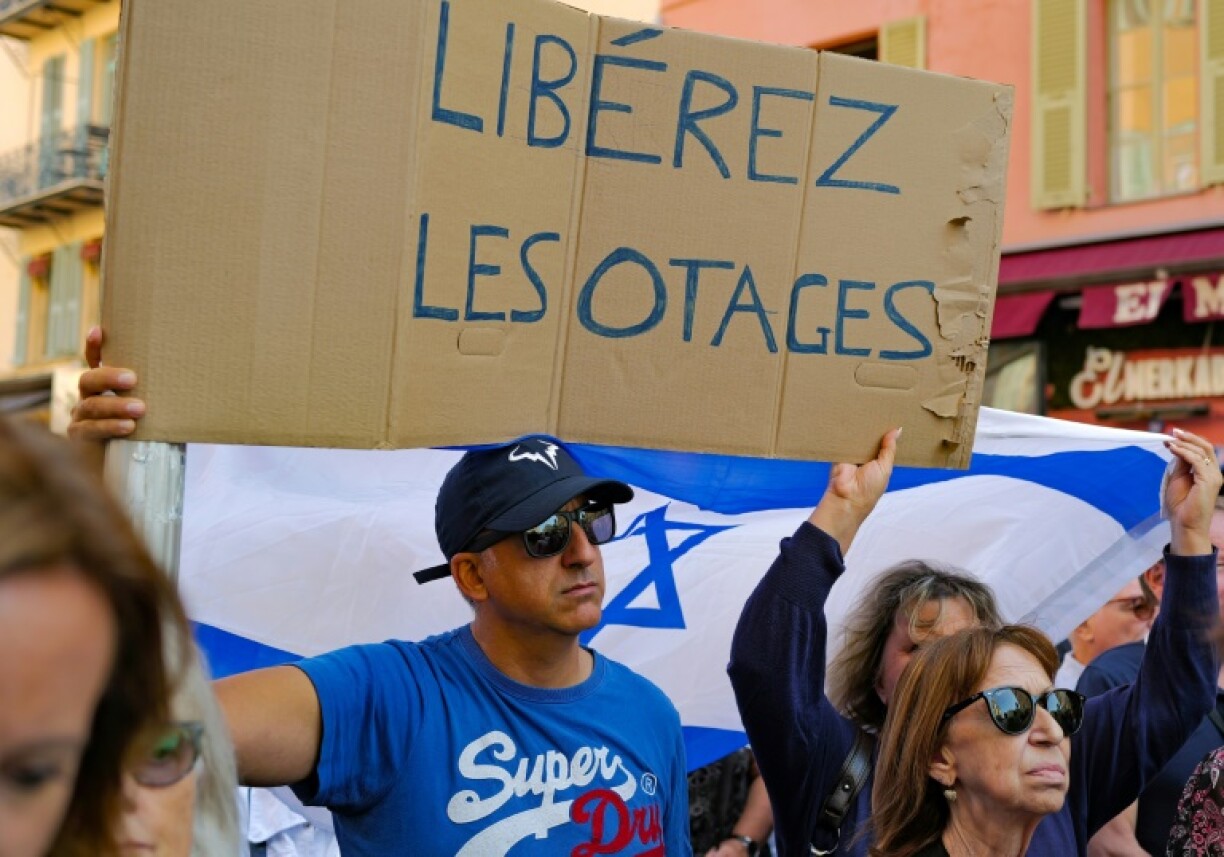 A demonstrator holds a placard reading