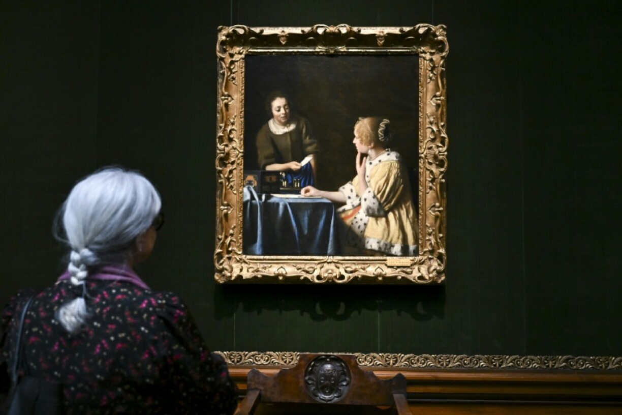 A woman views 'Mistress and Maid' by Johannes Vermeer at the Frick Collection in New York