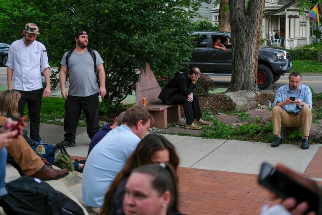 Hotel guests and employees who were evacuated wait outside after an attack in Boulder on demonstrators calling for the release of Israeli hostages held in Gaza