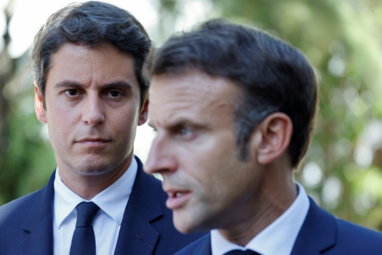 Le ministre français de l'Éducation Gabriel Attal (G), regarde le président français Emmanuel Macron (D) lors d'une visite au lycée professionnel de l'Argensol à Orange, dans le sud-est de la France, le 1er septembre 2023