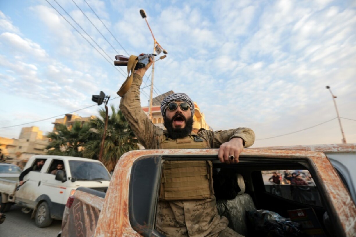 A Syrian rebel fighter cheers as he enters the central city of Hama