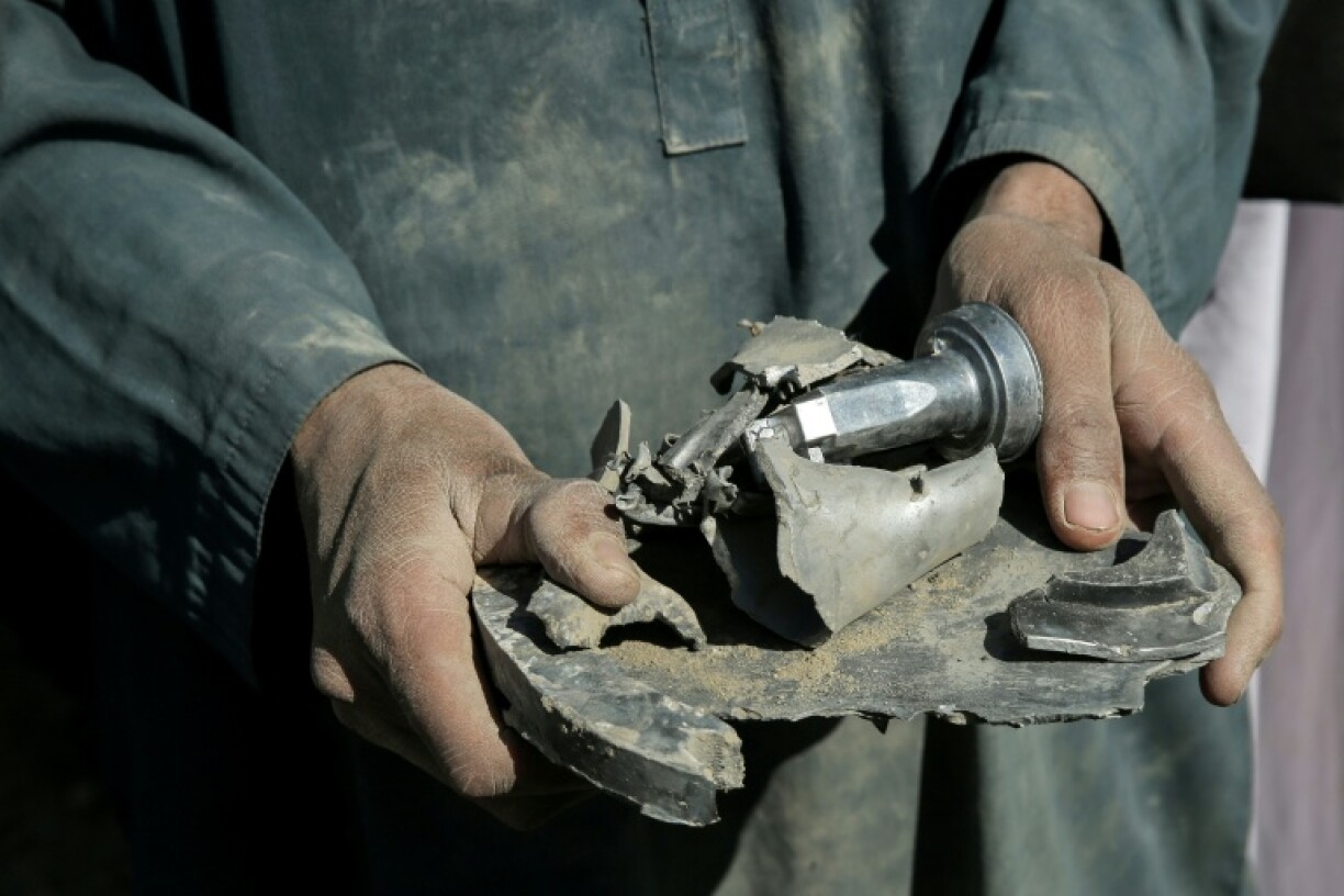 Un Afghan tient un fragment d'obus de mortier après des frappes aériennes du Pakistan à la frontière de l'Afghanistan, le 22 février 2026 dans la province de Nangarhar, dans l'est de l'Afghanistan