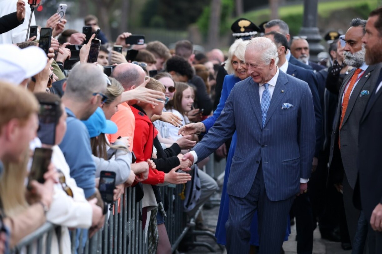 The king and queen shake hands and greet the crowd in Rome