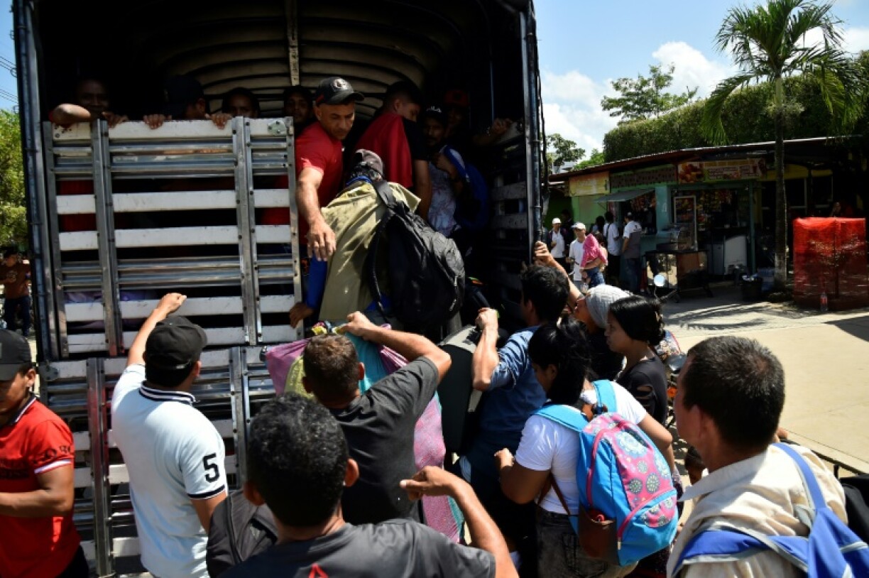 People displaced from recent clashes between armed groups board the back of a truck in the municipality of Tibu in Colombia