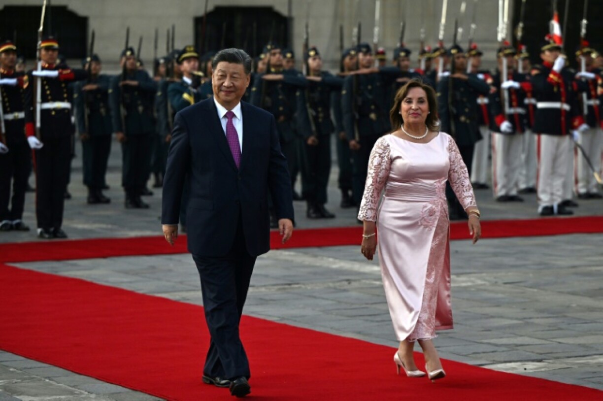 China's President Xi Jinping walks next to Peru's President Dina Boluarte at the government palace in Lima on November 14, 2024