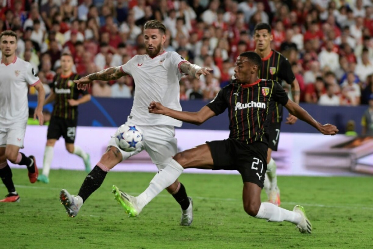 L'attaquant lensois Morgan Guilavogui (à dr) à la lutte avec le défenseur sévillant Sergio Ramos, lors du premier match de la phase de groupe de Ligue des champions le 20 septembre 2023 à Séville.