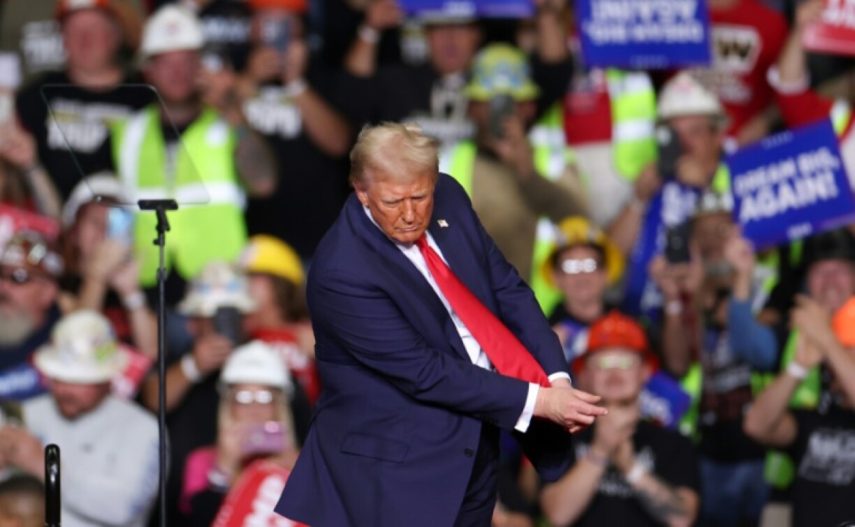 Former US President and Republican presidential candidate Donald Trump mimics playing golf on stage after speaking at a campaign rally at PPG Paints Arena in Pittsburgh, Pennsylvania on November 4, 2024.