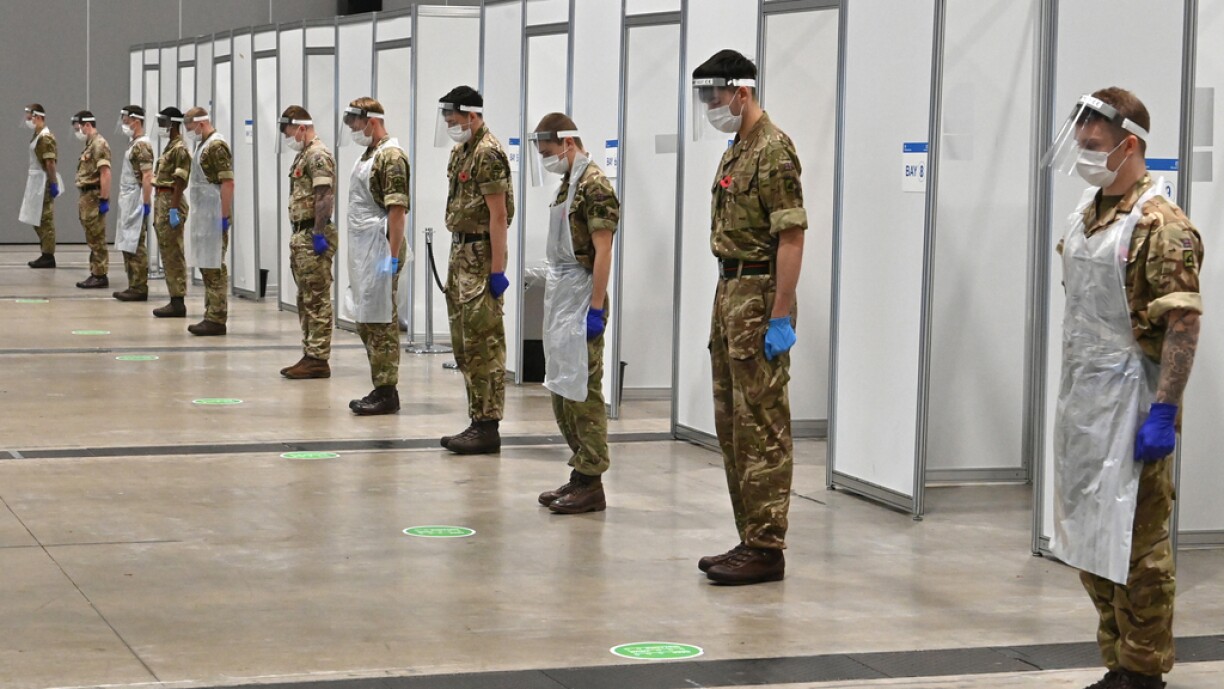 Soldiers observe a 2 minute silence for Armistice day in remembrance of the nations war dead on November 11, 2020 at a coronavirus rapid testing centre in the Liverpool exhibition centre in Liverpool, northwest England.