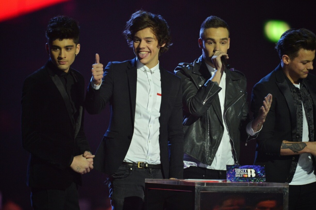 Harry Styles (2e g) et les membres du groupe pop britanno-irlandais One Direction, Zayn Malik, Liam Payne, Louis Tomlinson et Niall Horan, reçoivent le prix du succès mondial lors de la cérémonie des BRIT Awards 2013 à Londres, le 20 février 2013