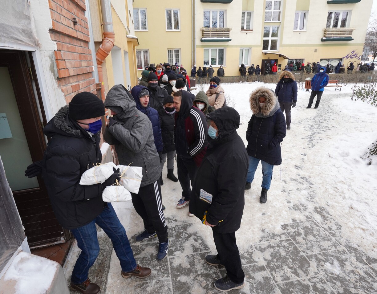 People stand in line to shop in a popular sweet shop in Warsaw for jam-filled doughnuts known as