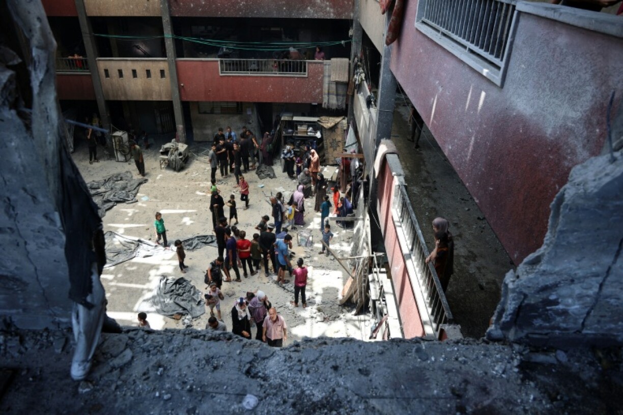 Displaced Palestinians check the damage following an Israeli strike on a school-turned-shelter in Gaza City