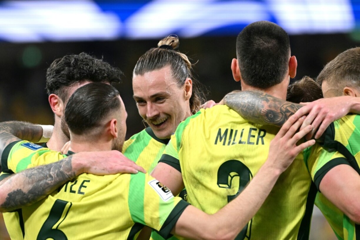 Jackson Irvine (C) celebrates with teammates after scoring Australia's third goal against Indonesia