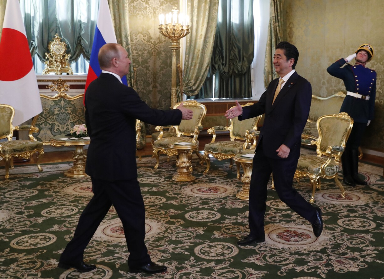 Russian President Vladimir Putin (L) welcomes Japanese Prime Minister Shinzo Abe at the Kremlin in Moscow on May 26, 2018