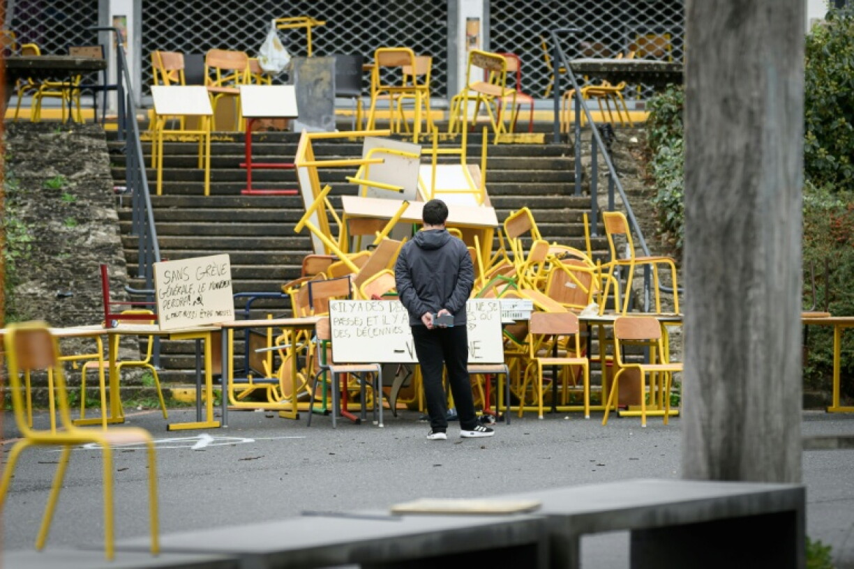 A student stands in front of the blocked entrance to a building at the University of Rennes