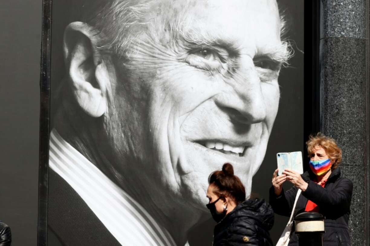 Deux passantes devant le portrait de feu le prince Philip, à Windsor (Royaume-Uni), le 16 avril 2021