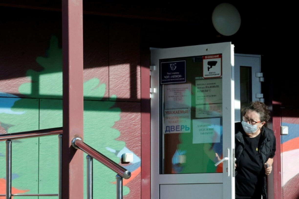 A security person wearing a face mask looks out from the door of an infectious diseases hospital in the town of Shelekhov, where an employee of the Irkutsk Antiplague Research Institute had died on October 7, 2026
